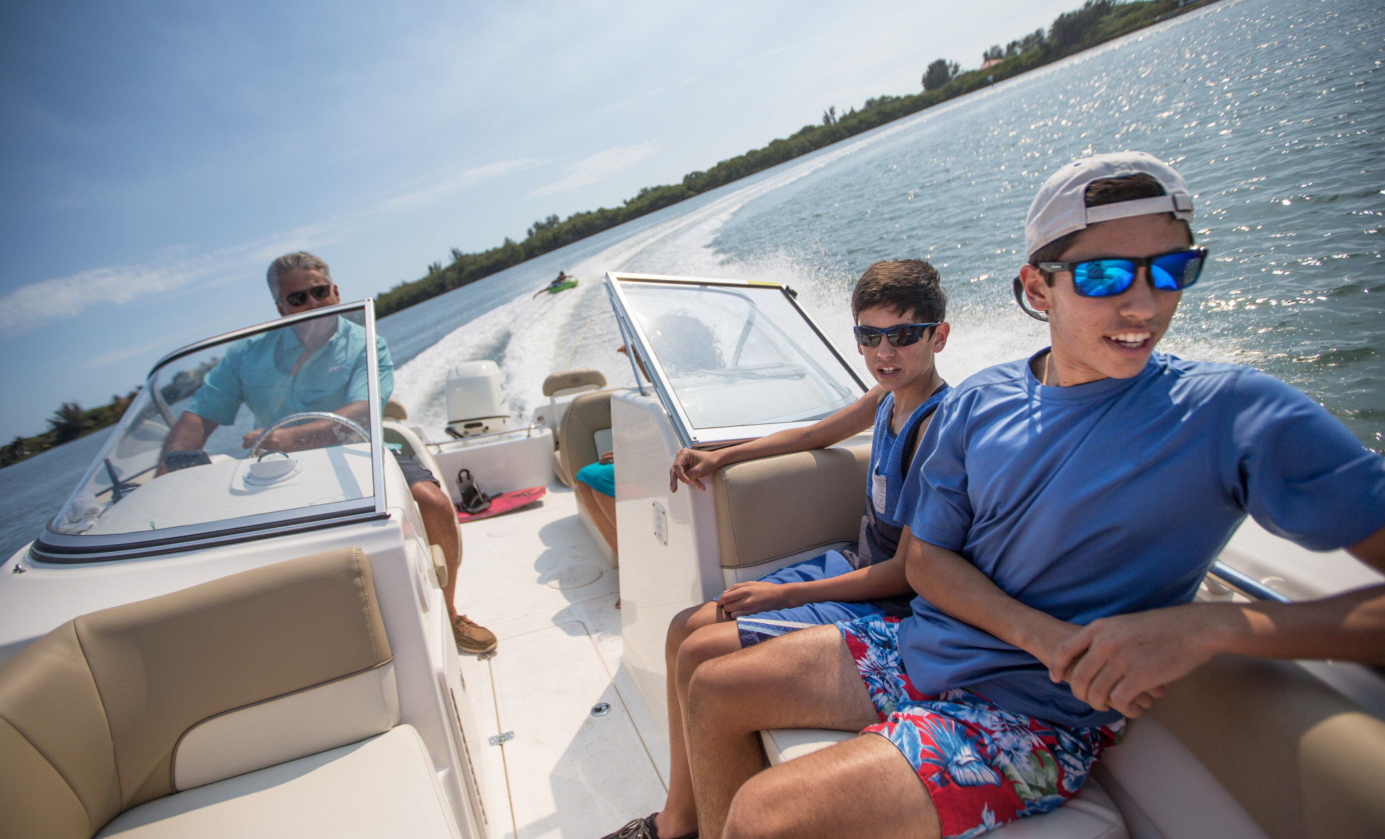 Family on boat towing innertube